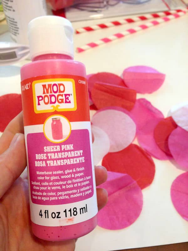 Mod Podge Sheer colors in pink in front of a pile of punched out tissue paper circles