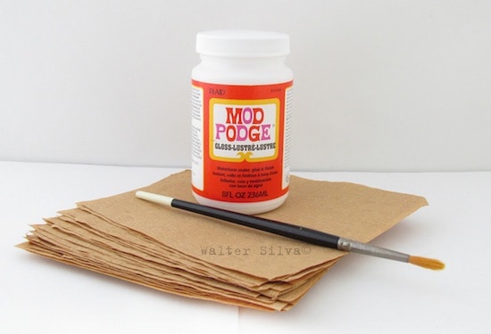 Pile of rice paper, a paint brush, and Mod Podge Gloss
