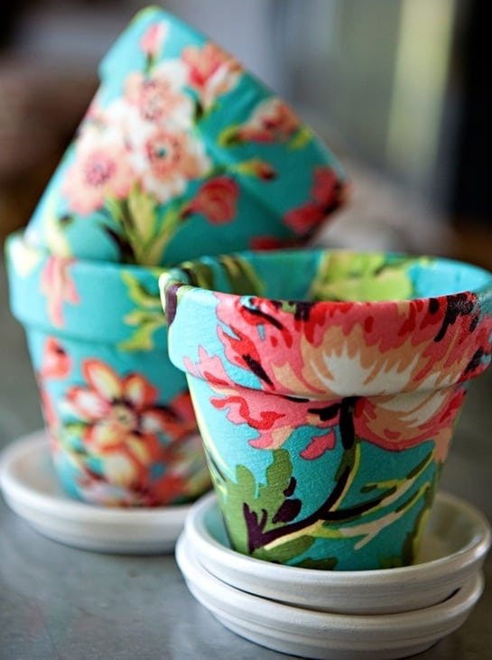 Decoupage fabric on terra cotta in this fun DIY flower pot project. You'll love the transformation from boring to fun and pretty!