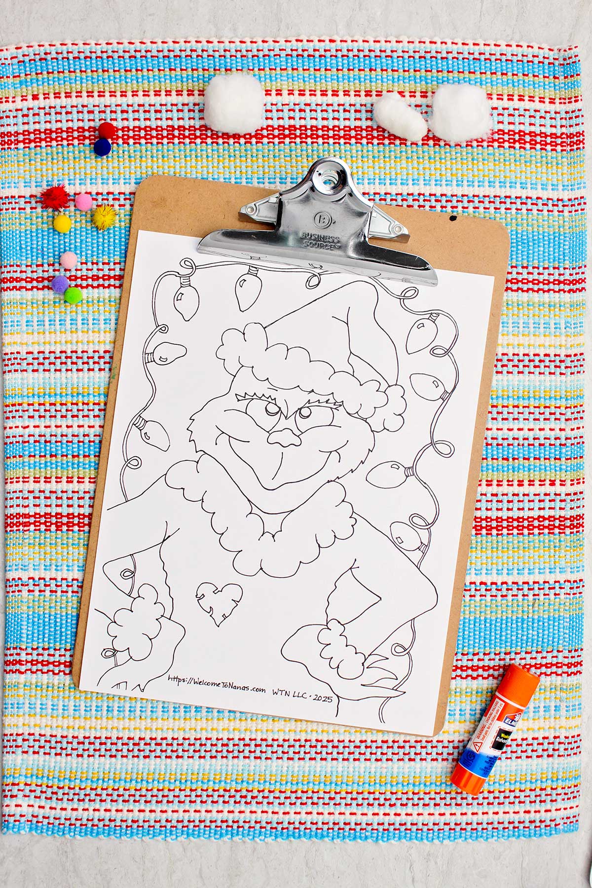 Uncolored Grinch coloring page on a clipboard.