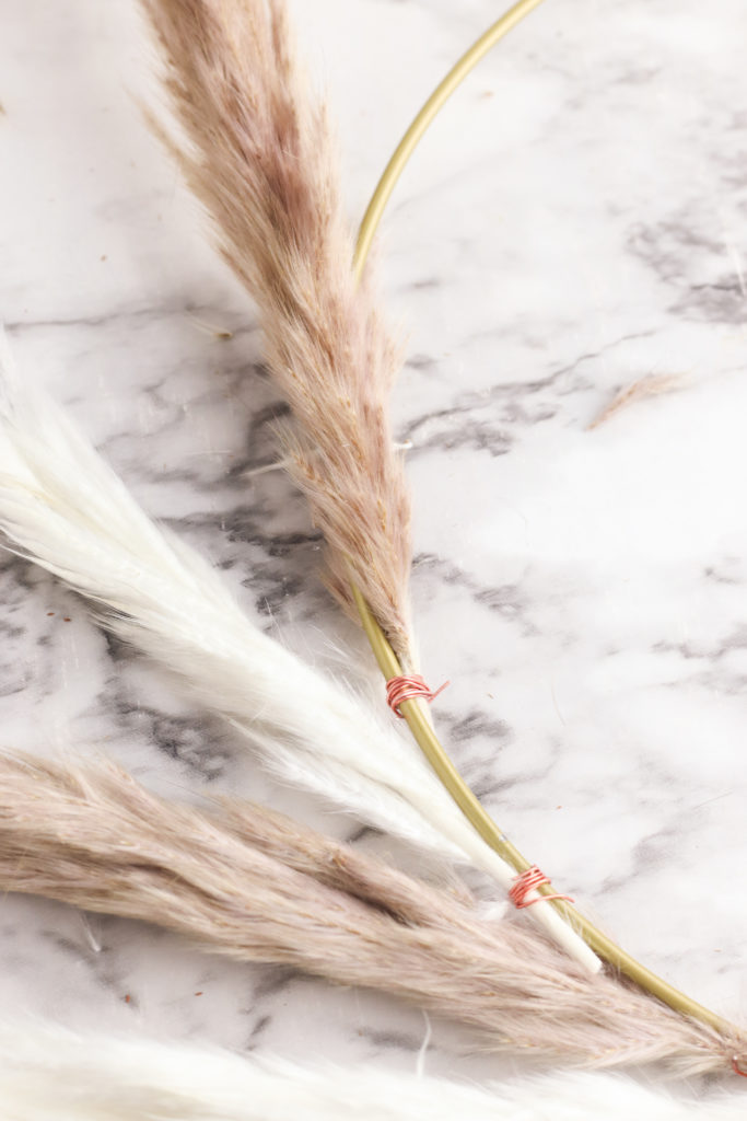 Add more pampas grass to the hoop wreath with floral wire.