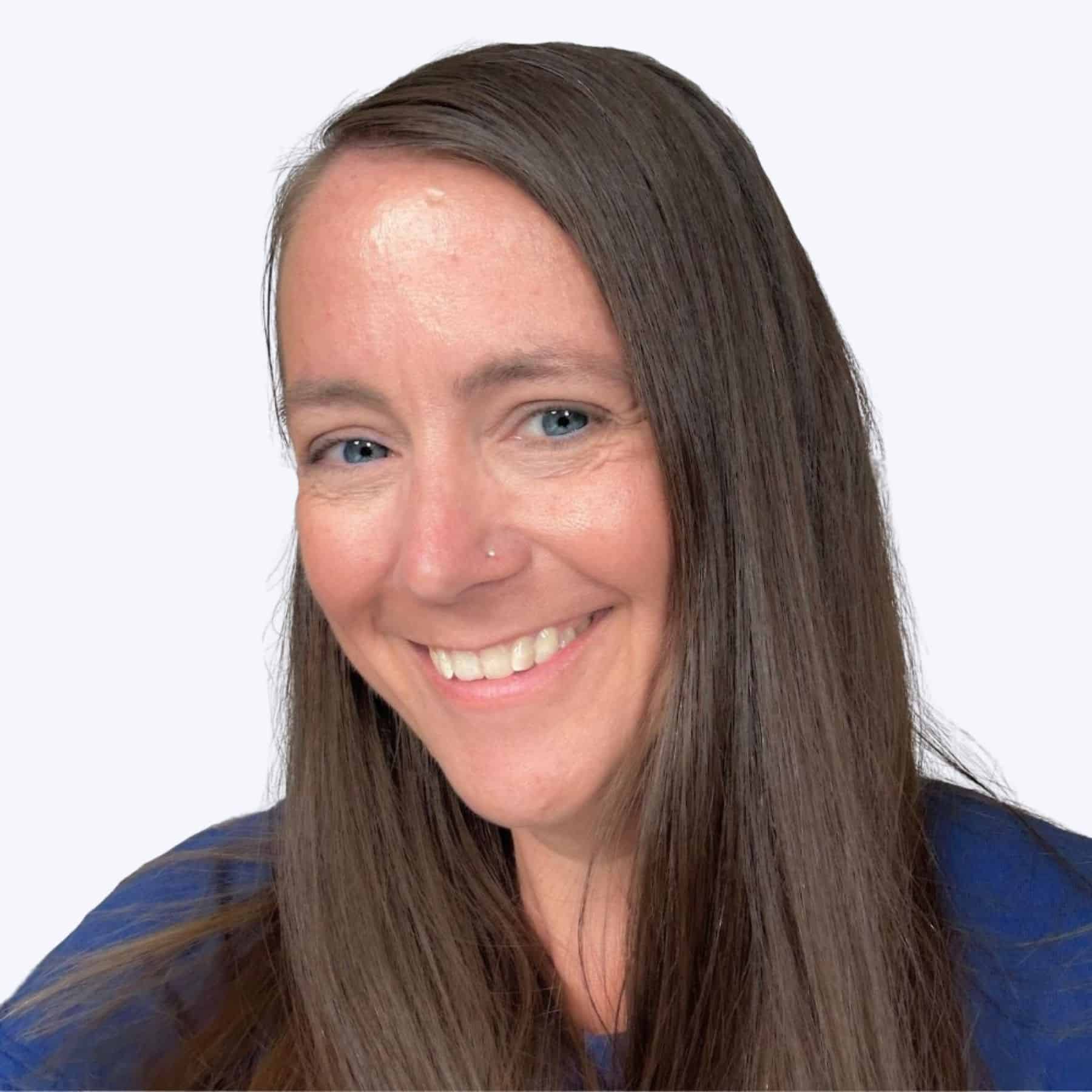 Close-up headshot of a smiling woman with long straight hair and a nose stud, wearing a dark top against a plain background.