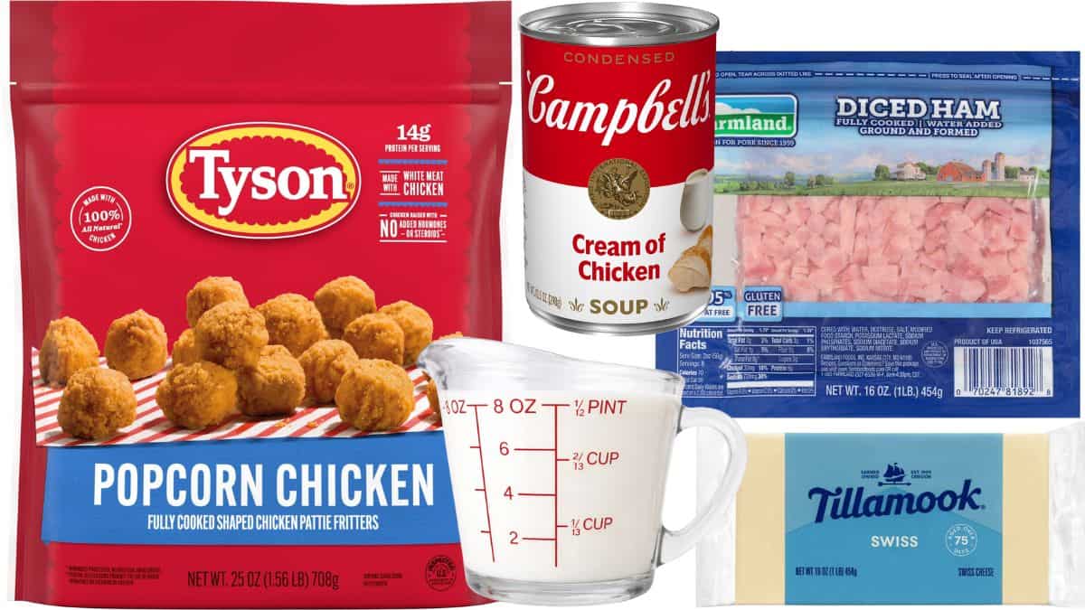 Packaged ingredients for a chicken cordon bleu casserole, including popcorn chicken, diced ham, cream of chicken soup, Swiss cheese, and a measuring cup of milk.
