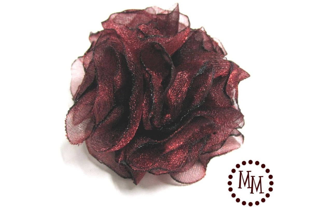 Handmade singed organza pom pom flower with layered, heat-sealed fabric petals, shown as a finished fabric flower embellishment on a white background.