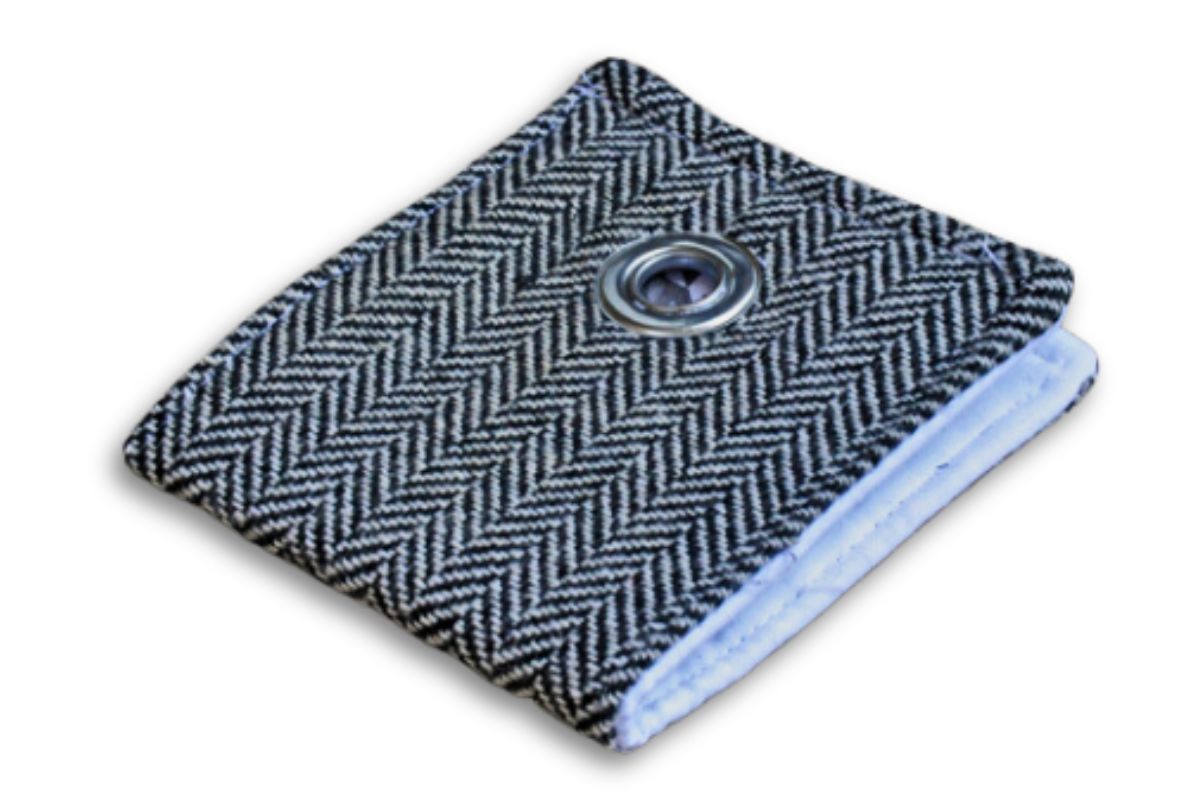 Compact fabric wallet in a stylish black-and-white herringbone pattern, featuring a central silver grommet detail and neatly stitched edges.