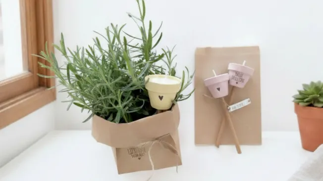 mini garden torches in pastel tones made from colorful clay pots in a rosemary