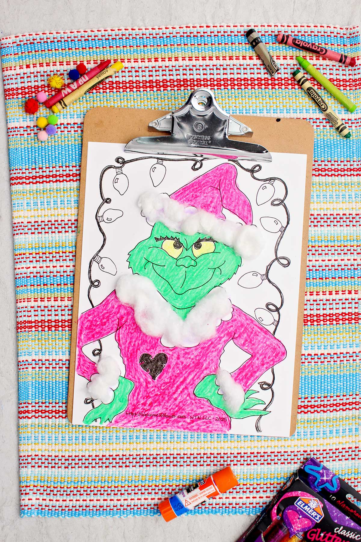 Completed Grinch colored printable complete with cotton ball accents clipped into a clip board.